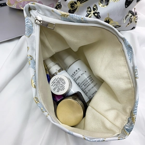Detail view of large capacity blue butterfly cosmetic bag with gold embroidery storage space