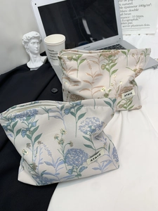 Detailed view of floral canvas makeup bags with zippers and embroidered floral accents