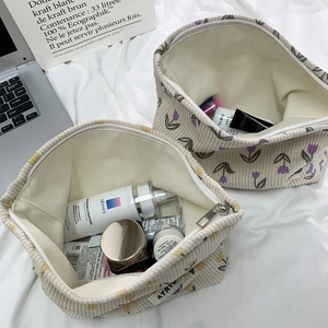 Detail view of corduroy cosmetic bag interior with floral patterns and spacious storage