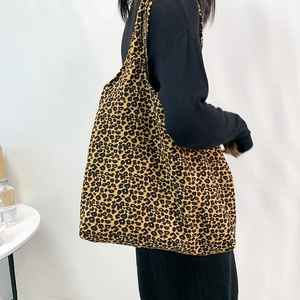 Vue détaillée du grand sac cabas en velours côtelé léopard porté à l'épaule pour le style