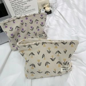 Macro detail of tulip floral corduroy makeup bag with textured fabric and secure zipper