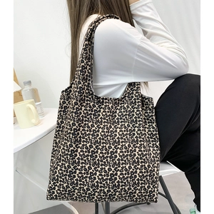 Détail d'un grand sac cabas en velours côtelé à imprimé léopard porté par un mannequin
