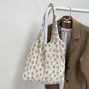 Close-up of cream corduroy tote bag featuring delicate purple tulip floral patterns