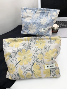 Macro view of floral jacquard fabric texture and brand label on large cosmetic bags