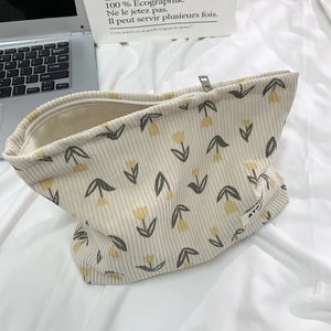 Detailed texture of floral corduroy makeup bag with tulip patterns and metal zipper