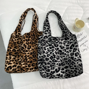 Gros plan de sacs cabas en velours côtelé léopard marron et gris sur un lit blanc