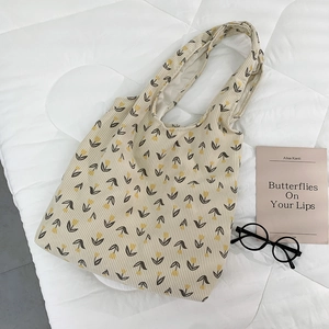 Detail of beige corduroy tote bag with yellow tulip pattern and soft textured fabric