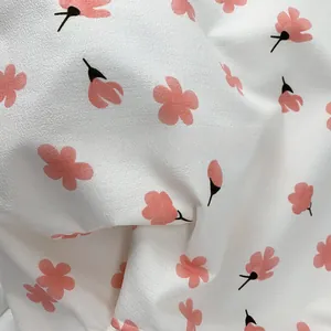 Close-up of soft floral canvas fabric showing pink cherry blossom patterns and texture