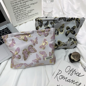 Close-up of butterfly print cosmetic bags with gold foil accents and zipper detail