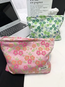 Détail de trousses de maquillage en jacquard floral avec étiquettes de logo et motifs