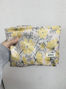 Close-up of yellow daisy jacquard fabric on a portable cosmetic storage bag