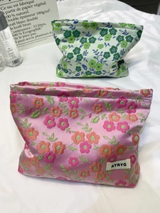 Gros plan de trousses de maquillage en jacquard floral avec texture satinée chic