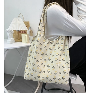 Detail of yellow corduroy tote bag featuring floral tulip patterns in a lifestyle setting