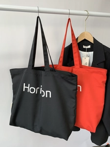 Detail view of stylish Horion canvas tote bags in red and black colors for daily commuting