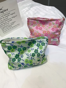Détail de trousses de maquillage en jacquard à fleurs avec tissu texturé et zip
