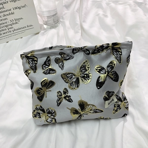 Detail of grey butterfly cosmetic bag with embroidery and branded side label