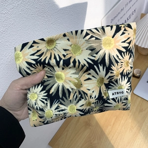 Floral makeup bag with yellow daisy print and ATRYG woven label for travel storage