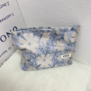 Close-up of light blue floral jacquard fabric with daisy pattern and ATRYG brand label