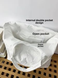 Internal structure of white quilted tote bag featuring open pocket and zipper pocket