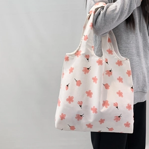 Detailed side view of floral canvas tote bag with pink cherry blossom prints