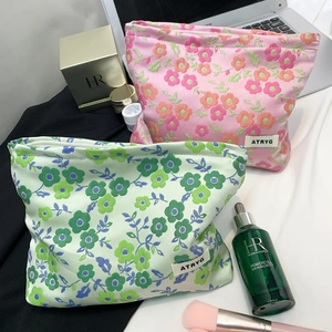 Gros plan de trousses à maquillage jacquard à fleurs avec étiquette de marque en ambiance
