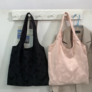 Detail of butterfly embossed texture on pink and black canvas shoulder tote bags