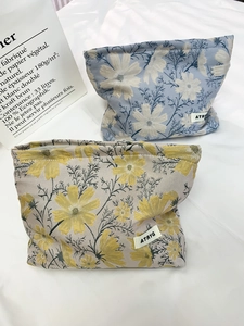 Close-up of jacquard travel cosmetic bags with floral daisy patterns and zipper closure