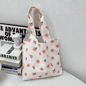 Detail of floral canvas tote bag with pink flower patterns and wide shoulder straps