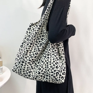 Vue latérale du grand sac cabas en velours côtelé léopard porté par un mannequin