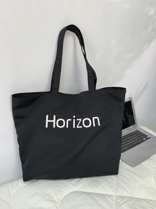 Detail shot of black canvas tote bag with Horizon text and durable fabric texture