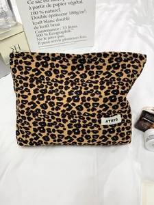 Leopard print canvas makeup bag with large capacity and zipper closure on a white fabric base