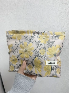Close-up of floral jacquard fabric texture and brand label on a portable makeup bag