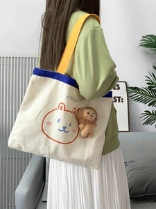 Detail der süßen Segeltuch-Tasche mit gelbem Gurt und braunem Plüsch-Löwen-Anhänger