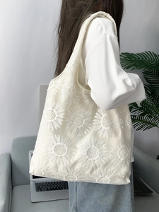 Détail de la broderie florale de marguerite sur le sac cabas en toile blanc cassé