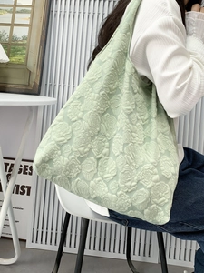 Detail of light green tote bag with 3D embossed rose floral texture on fabric