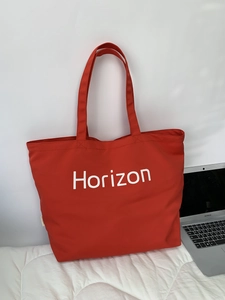 Detail of red canvas tote bag with white Horizon print and durable woven texture