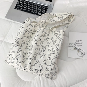 Top view of white floral tote bag with black rabbit print and interior details
