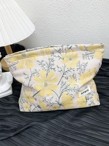 Close-up of floral jacquard fabric and brand label on a large travel cosmetic bag