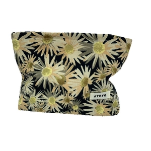 Floral makeup bag with black fabric and daisy print pattern for travel storage