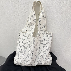 Close-up of minimalist white canvas tote bag with hand-drawn rabbit pattern print