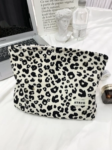 Detail of leopard print toiletry bag with zipper and ATRYG brand tag on fabric