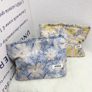 Detail of floral jacquard fabric and woven label on large capacity cosmetic storage bags