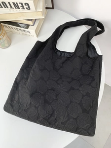 Close-up of textured black tote bag with 3D embossed rose pattern for daily commute
