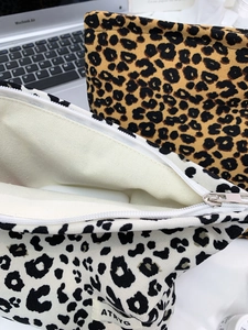 Detail of leopard print knitted makeup bags with silver zippers and internal storage space