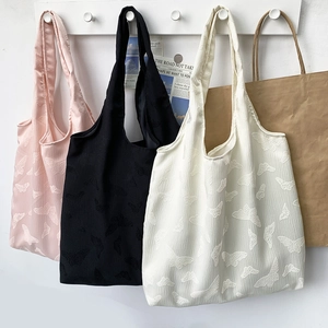 Detail of embossed butterfly texture on large capacity tote bags in multiple colors