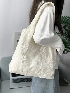 Gros plan sur le sac en filet blanc avec broderie tournesol 3D et large bandoulière