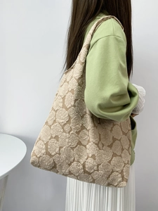 Detail of elegant shoulder tote bag with embossed beige rose floral texture on fabric
