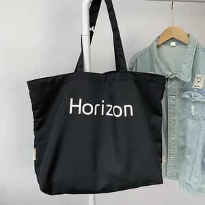 Minimalist black canvas tote bag with Horizon print and spacious commuter style