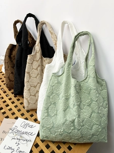 Row of embossed rose tote bags in green, cream, apricot, black, and brown colors
