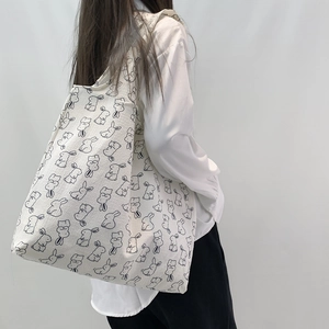 Close-up of large canvas tote bag with black rabbit print on off-white fabric